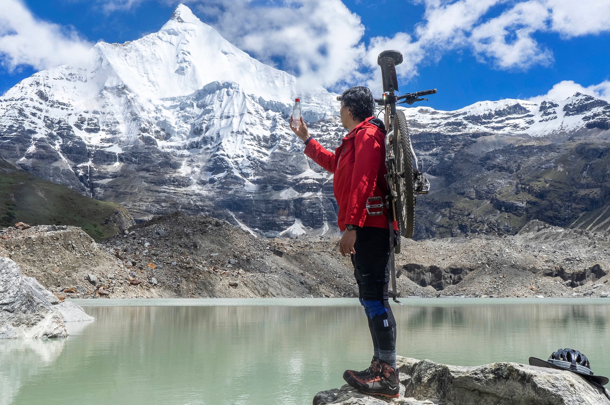 Jamyang in the mountains, with the plastic water bottle filled with glacial melt-water.